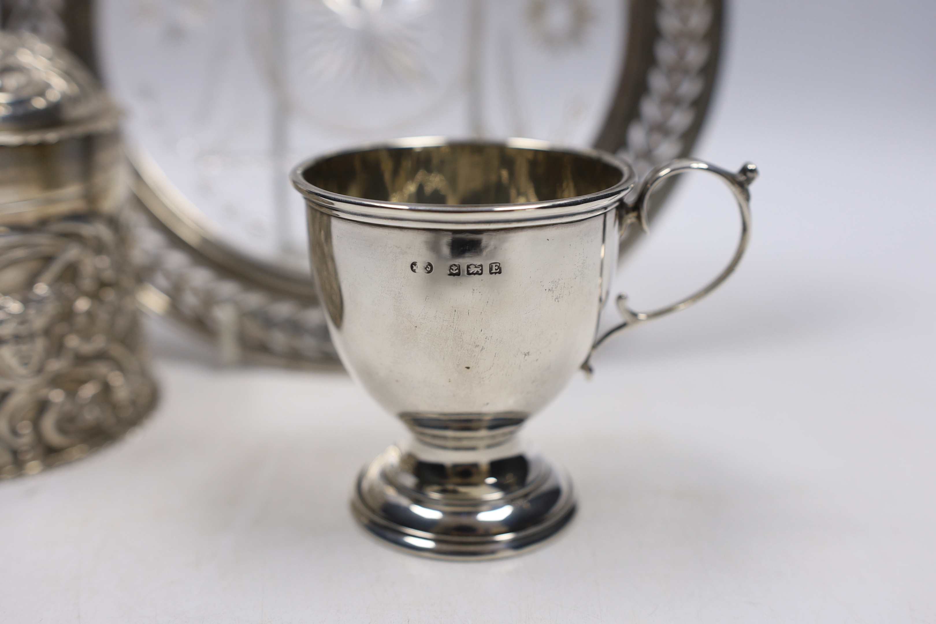 A late Victorian repousse silver cannister and cover, by William Comyns, London, 1896, 92mm a sterling mounted glass stand and a small silver cup.
